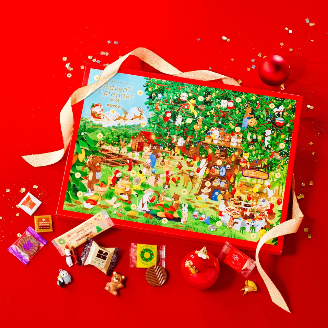 Festive scene with Royce’ 2024 Advent Calendar featuring woodland creatures, chocolates, a red tin with figurine, and assorted chocolate figures arranged decoratively.