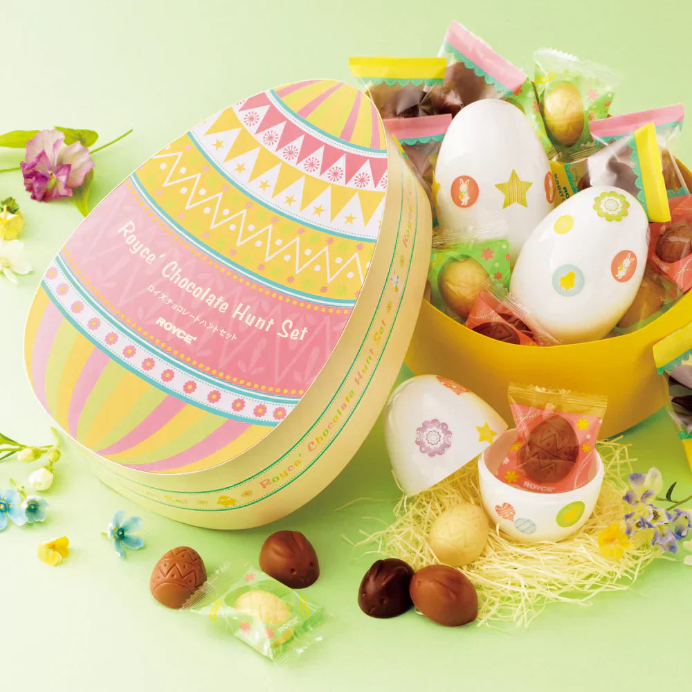 Easter-themed Royce’ Chocolate Hunt Set with pastel-striped egg-shaped box, featuring assorted milk, dark, and white chocolate eggs and bunnies, plus decorated plastic eggs.