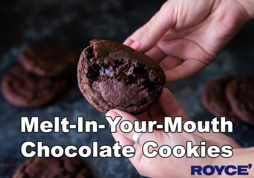 Hands break a dark chocolate cookie, revealing a gooey center; more cookies rest behind. Text: Melt-In-Your-Mouth Chocolate Cookies. Royce’ logo included.