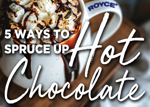 Steaming mug of hot chocolate with toasted marshmallows, chocolate drizzle, and ROYCE’ on the rim. Text overlay reads: 5 WAYS TO SPRUCE UP Hot Chocolate.