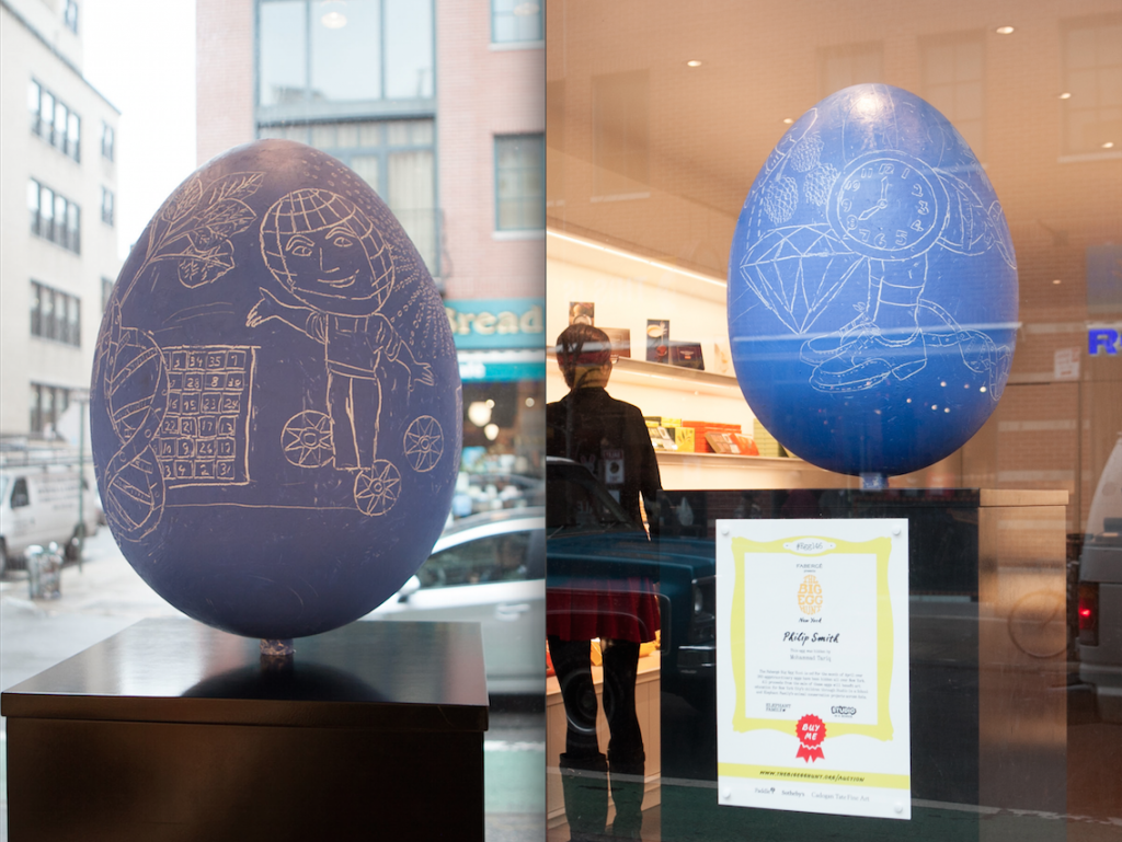 Two large blue Faberge egg sculptures with white-line drawings, one outdoors with doodles, the other indoors with sketches, by artist Philip Smith.