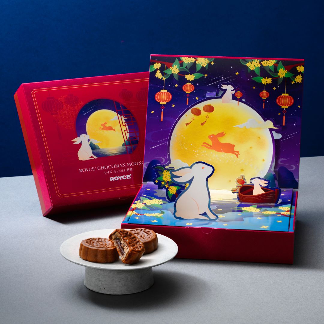 Chocoman Mooncake—three mooncakes on a plate, one cut open, with gift box featuring rabbit and lantern pop-up diorama behind.