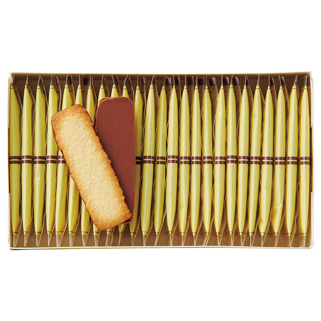 Baton Cookies Coconut image shows an open box with individually-wrapped cookies with yellow packaging and two cookies coated with milk chocolate.