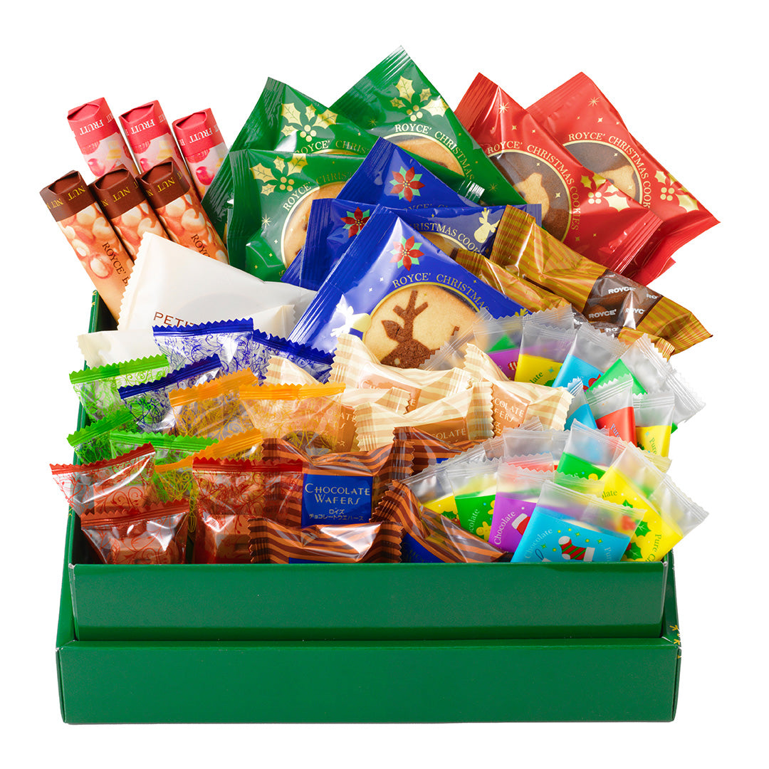 Image shows a green box filled with individually-wrapped chocolates in different shapes and sizes. Background is in white.