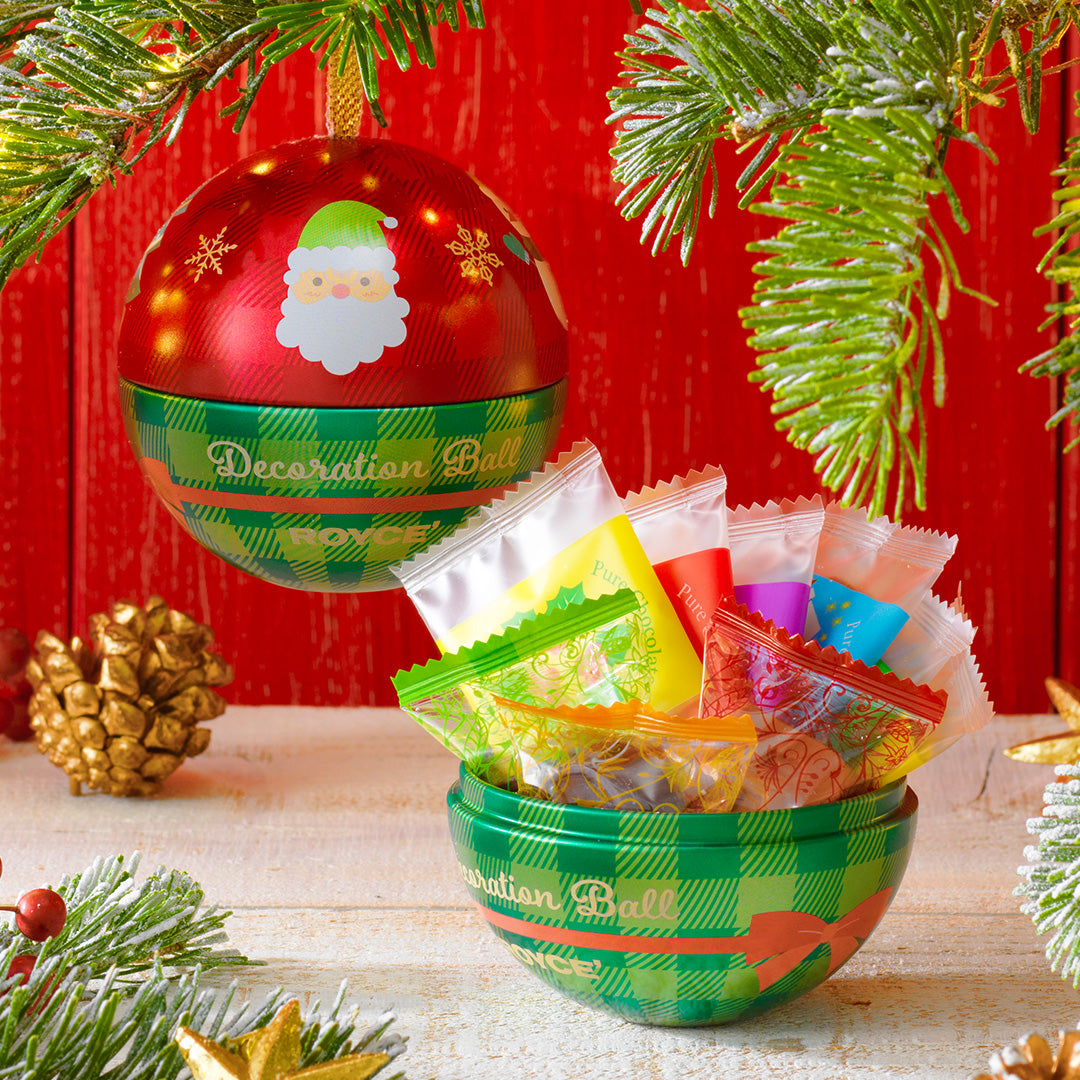 Image shows decoration balls in green and red with illustrations of snowflakes, ribbons, and Santa Claus. Background is in red and white and includes accents of leaves and a gold acorn.