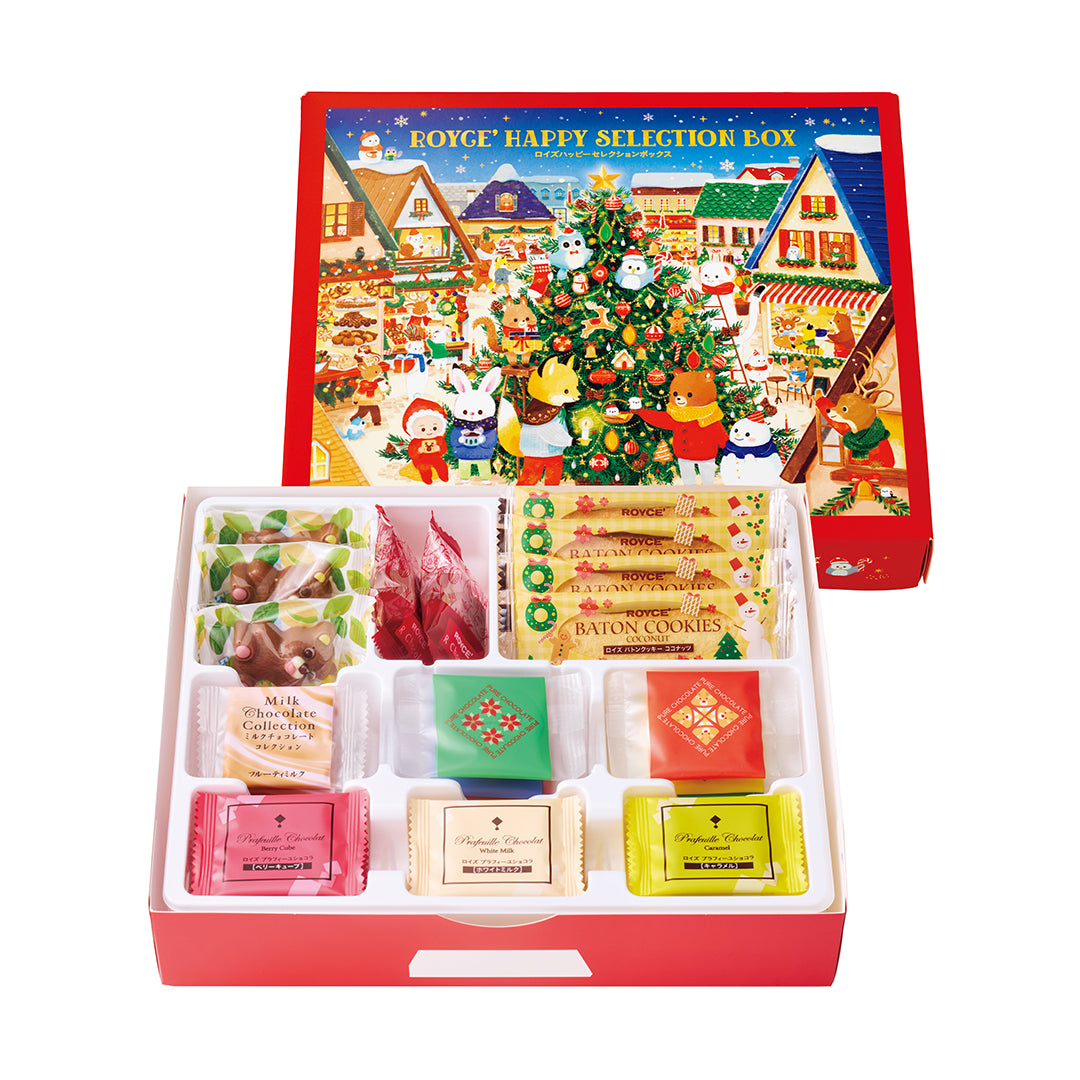 ROYCE' Happy Selection Box with festive lid, showing assorted chocolates, coconut Baton Cookies, and reindeer-shaped confections, all neatly arranged in plastic compartments.