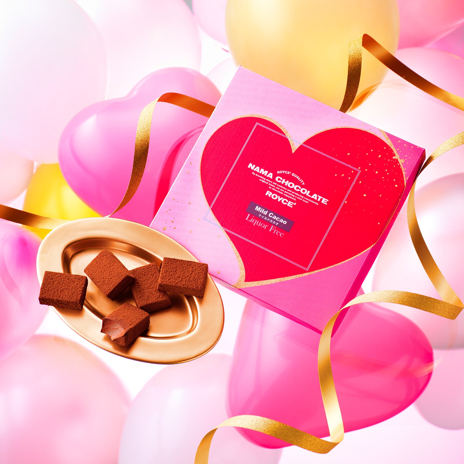 Image shows chocolates on a bronze plate and a box with a heart print. Background has balloons and ribbons in pink and gold. Visible text says ROYCE' Quality Nama Chocolate ROYCE' Mild Cacao Liquor Free.