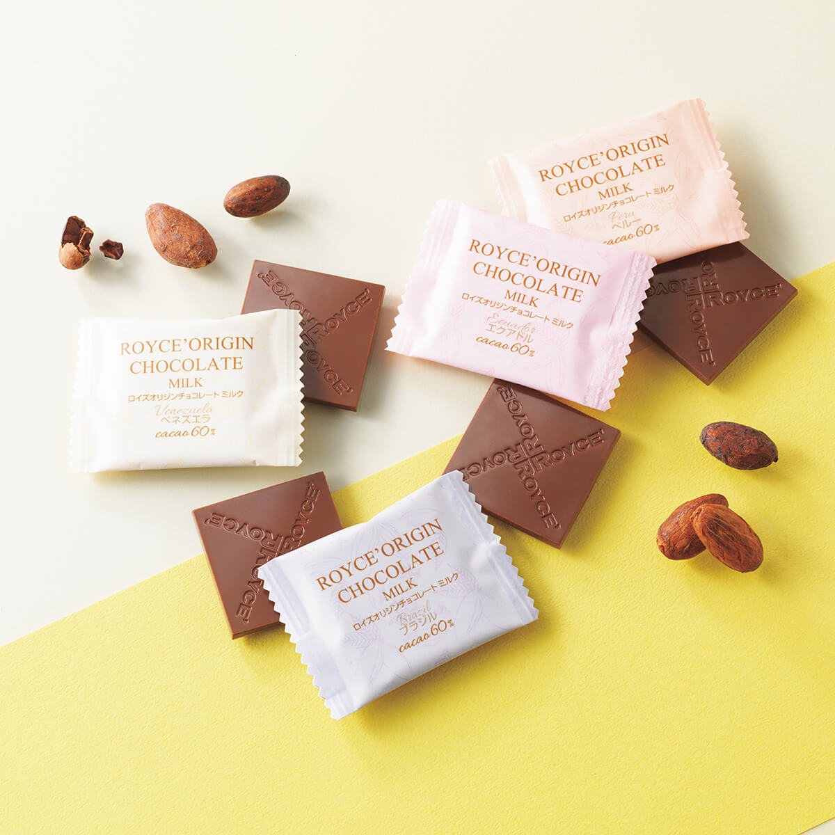 ROYCE' Chocolate - Image shows unwrapped and wrapped chocolate squares in brown and light hues of yellow, blue, pink, and orange. Accents include loose cacao beans.