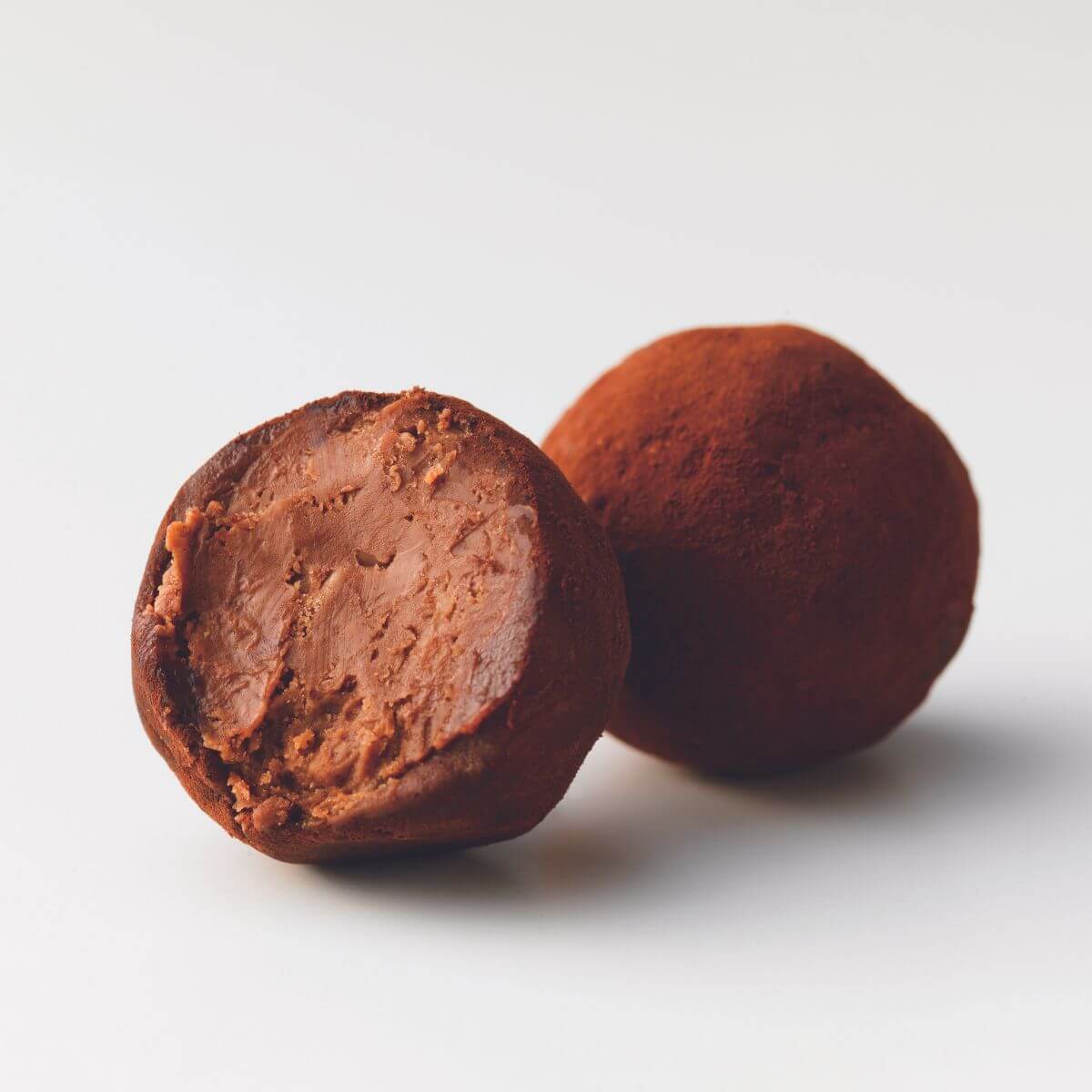 ROYCE' Chocolate - ROYCE’ Feuillantine Truffe “Gianduja” - Image shows brown chocolate truffles.