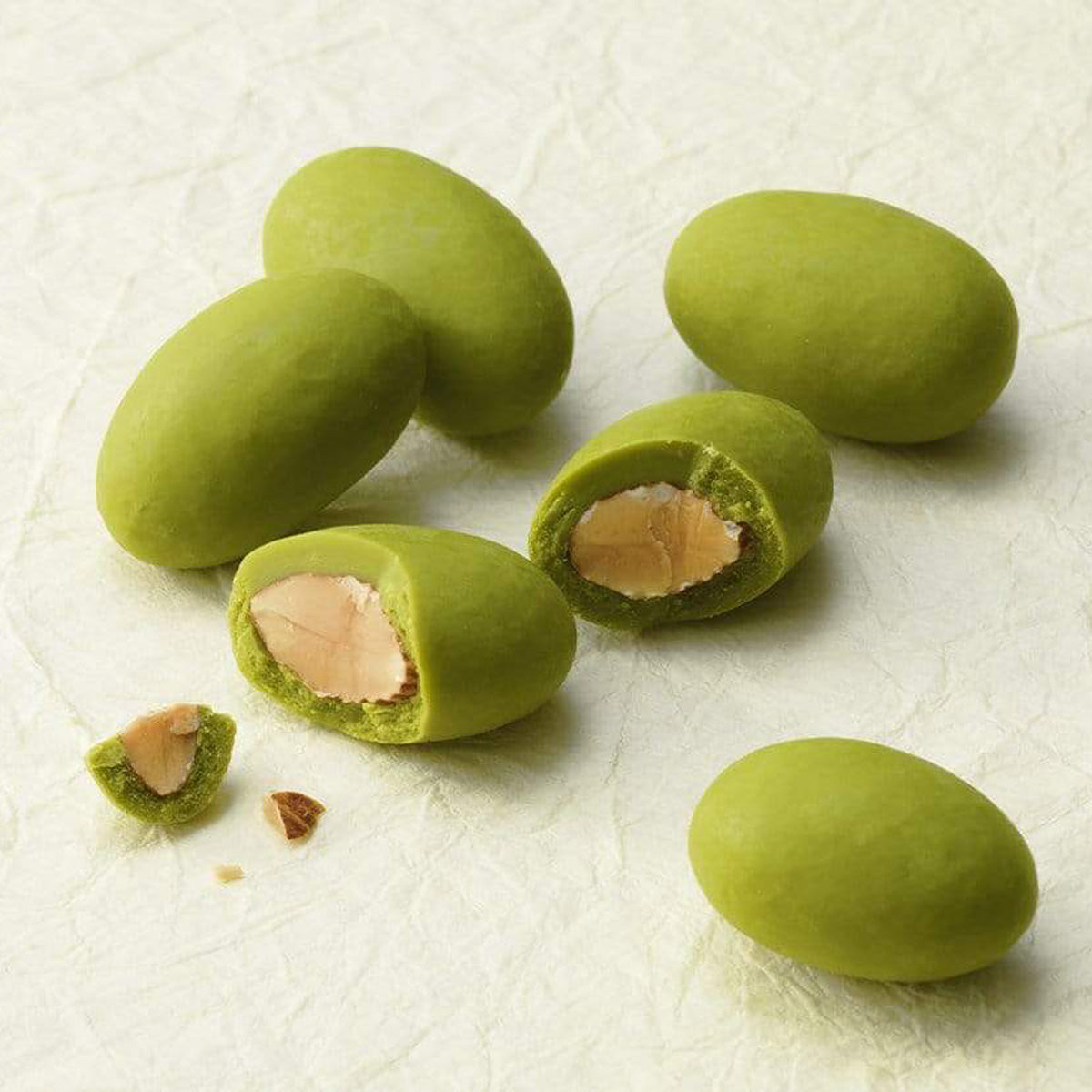 ROYCE' Chocolate - Matcha Almond Chocolate - Image shows round green chocolate-coated almonds on a white surface.