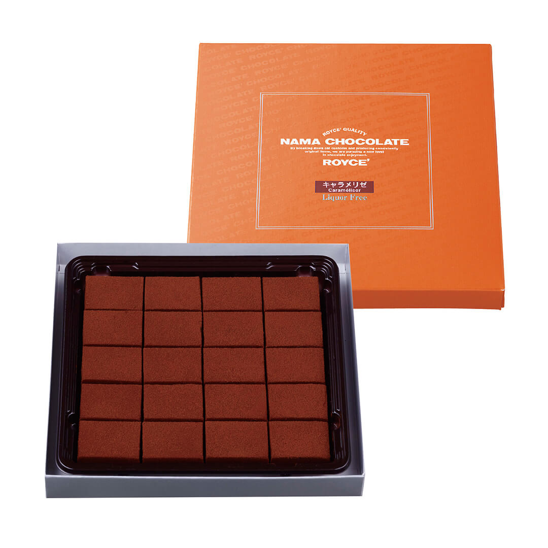 ROYCE' Chocolate - Nama Chocolate "Caraméliser" - Box on upper right shows an orange box with white background. Text in the middle says ROYCE' Quality Nama Chocolate ROYCE' Caraméliser Liquor Free. Box on lower left shows a gray box with a brown tray and chocolate blocks inside. Background is in white.
