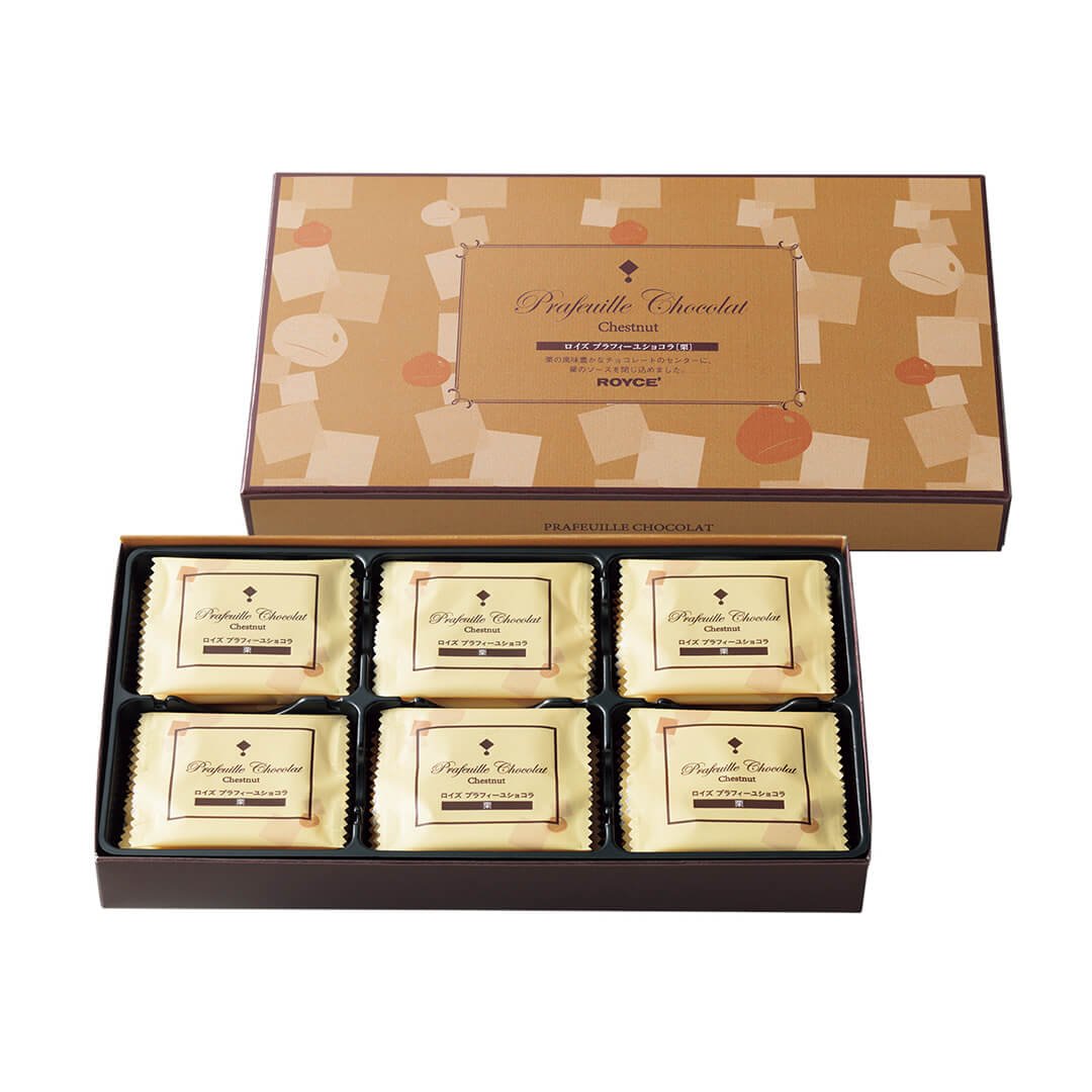 Image shows on top middle right a brown box with prints of squares and circles. Text in the middle says Prafeuille Chocolat Chestnut. ROYCE'. Text on bottom part says Prafeuille Chocolat. Box on lower middle left has a black tray filled with chocolates in yellow wrapping with text saying Prafeuille Chocolat Chestnut.