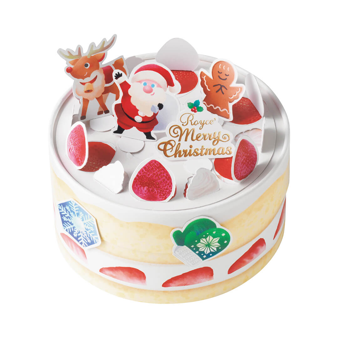 Image shows a round box in yellow and white with illustrations of strawberries in red, blue and white snowflake, and a pair of printed gloves in green and white. Seen on top are cutouts with illustrations of strawberries, a reindeer, a gingerbread angel, a Santa Claus, and a gold text saying ROYCE' Merry Christmas. Background is in white.