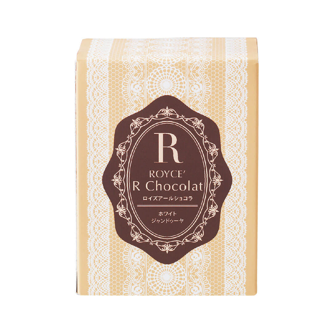 ROYCE' Chocolate - ROYCE' R Chocolat "White Gianduja" - Image shows a dark yellow box with white lace illustrations and a brown center. Text in the center says R ROYCE' R Chocolat. Background is in white.