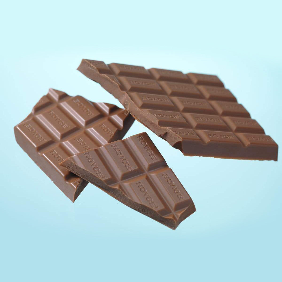ROYCE' Chocolate - Chocolate Bar "Creamy Milk" - Image shows two brown chocolate bars with the word "ROYCE'" engraved. Background is in blue.