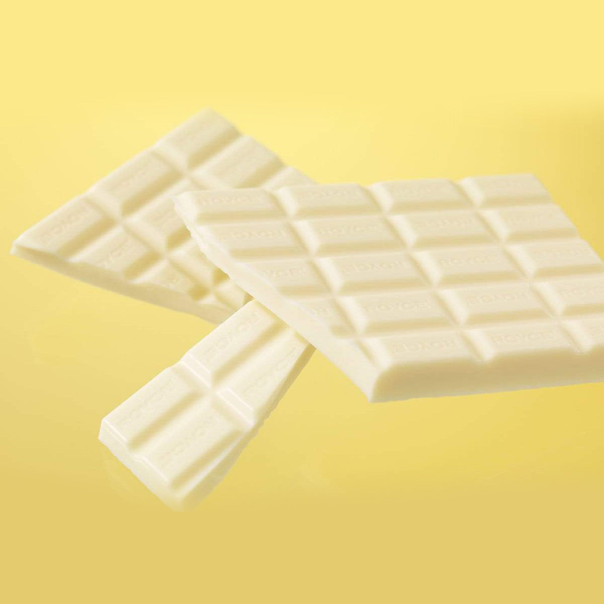 ROYCE' Chocolate - Chocolate Bar "White" - Image shows white chocolate bars and the word "ROYCE'" engraved. Background is in yellow.