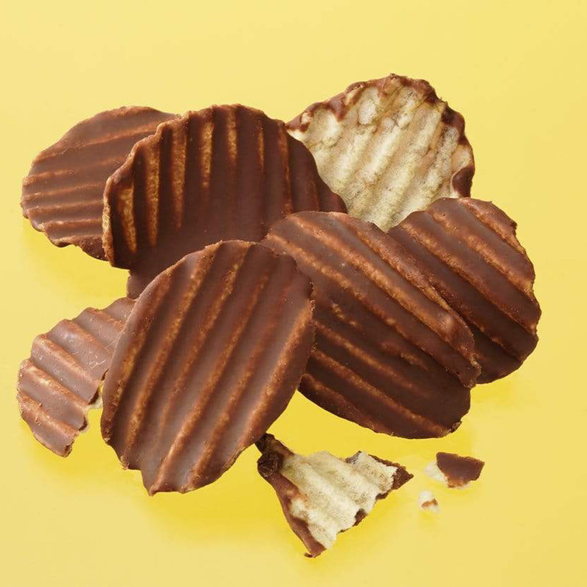 ROYCE' Chocolate - Potatochip Chocolate "Original" - Image shows brown chocolate-covered potato chips with a ridged texture. Background is in yellow color.