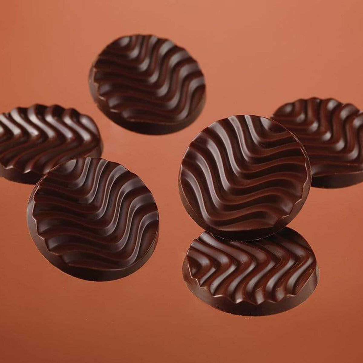 ROYCE' Chocolate - Pure Chocolate "Venezuela Bitter & Ghana Sweet" - Image shows dark brown chocolate discs with a waved texture. Background is in burgundy color.