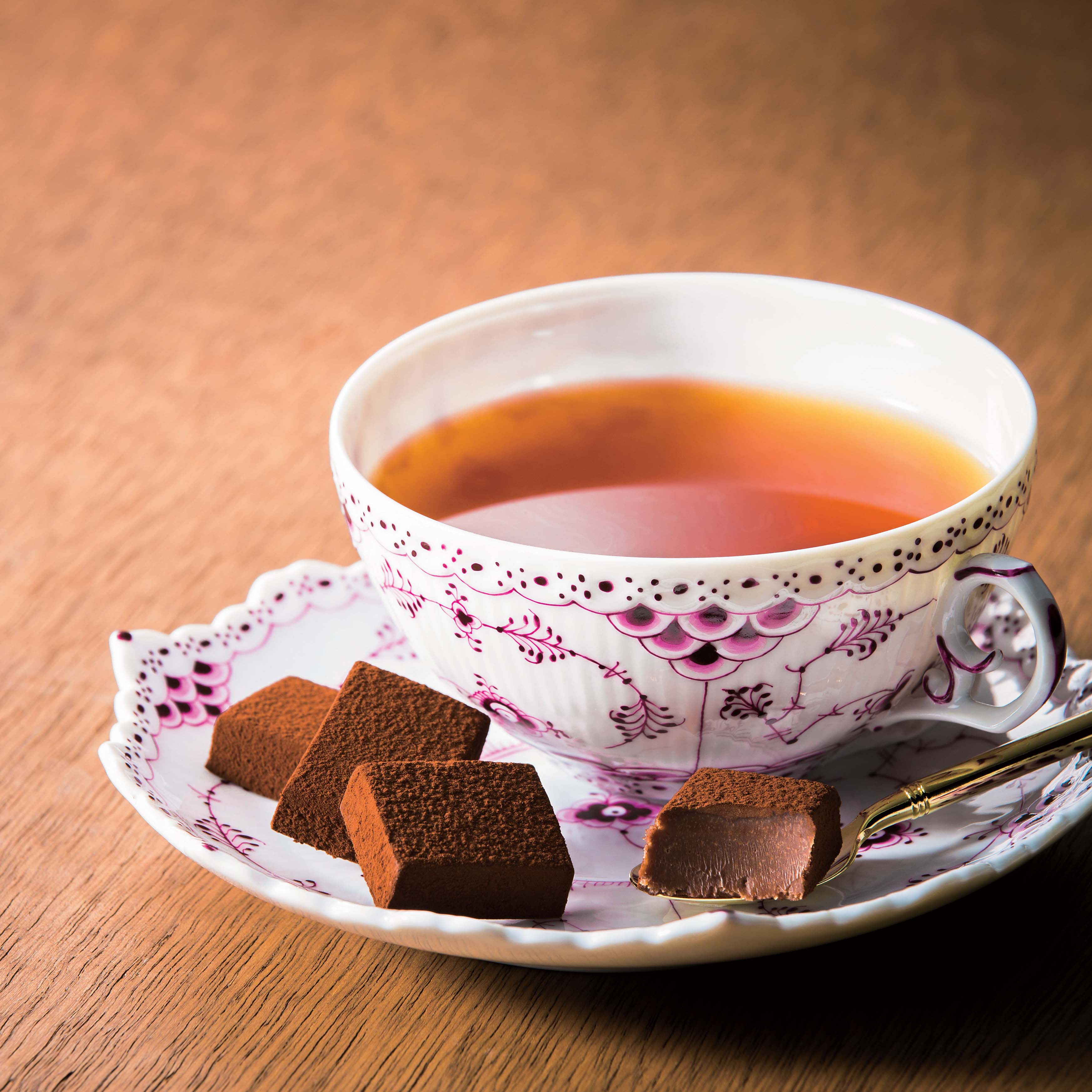 ROYCE' Chocolate - Image shows chocolate blocks on a plate with a cup of tea.
