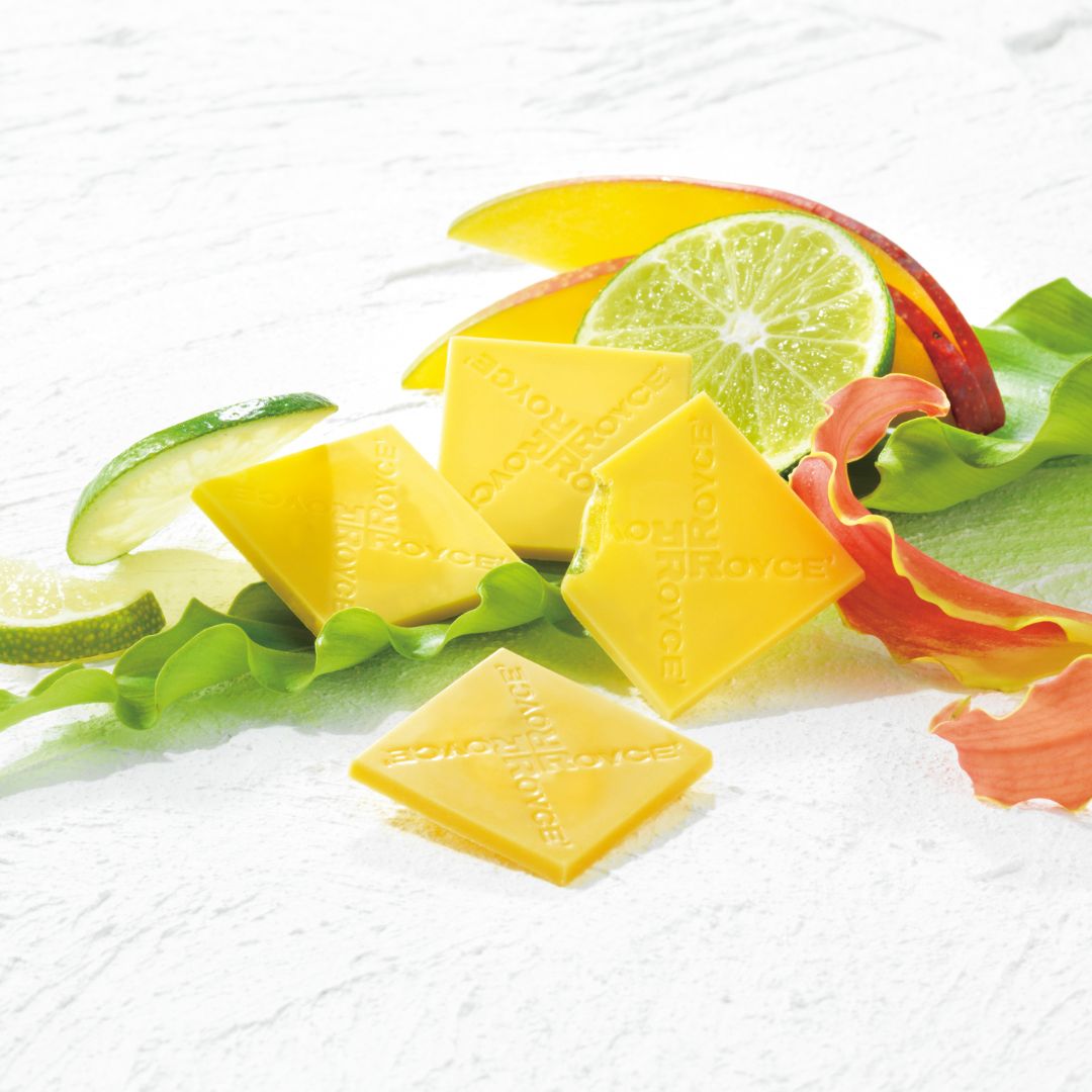 Image shows yellow chocolate squares with accents of leaves and fruits.