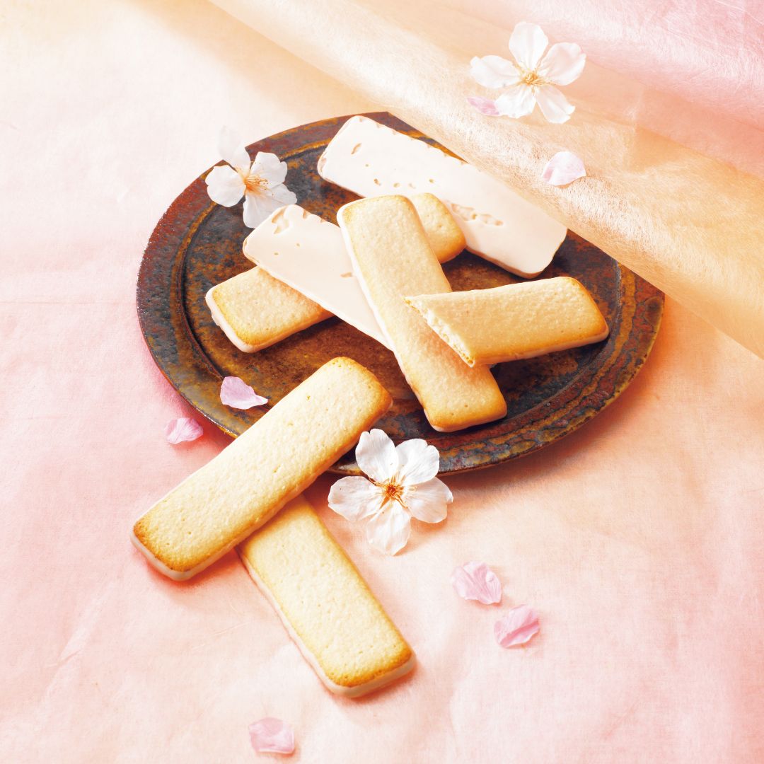 Image shows cookies on a brown plate with flowers for accents.