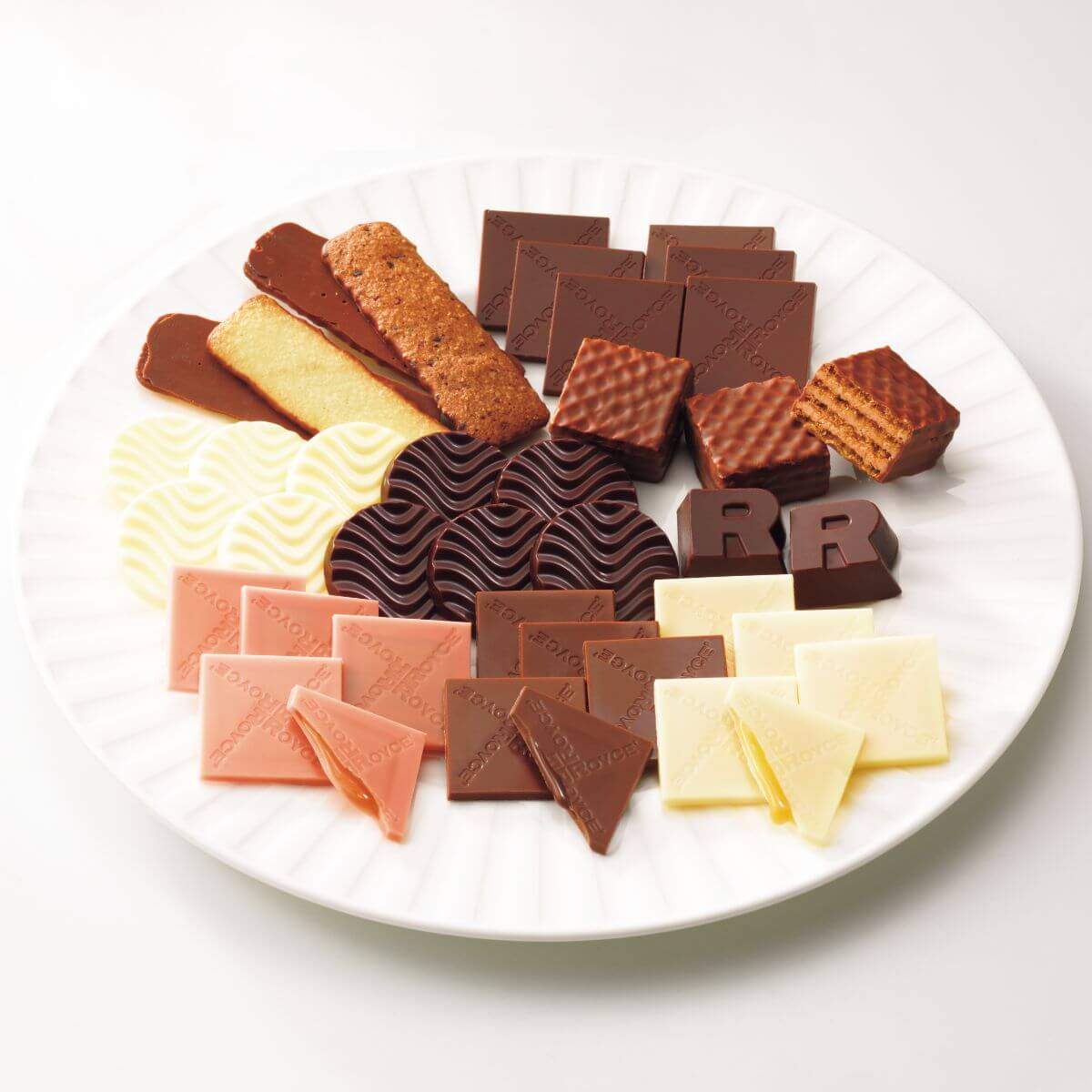 ROYCE' Chocolate - Chocolat No Shiki "Hokkaido" - Image shows confections in different shapes and colors in pink, brown, yellow, and white. The confections are on a white plate.