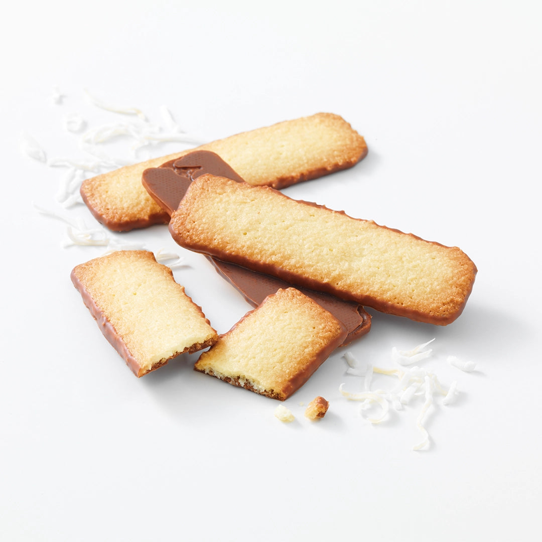 Baton Cookies Coconut (25 Pcs) featuring golden-baked, rectangular cookies half-dipped in milk chocolate, sprinkled with coconut shreds, offering a sophisticated blend of flavors.