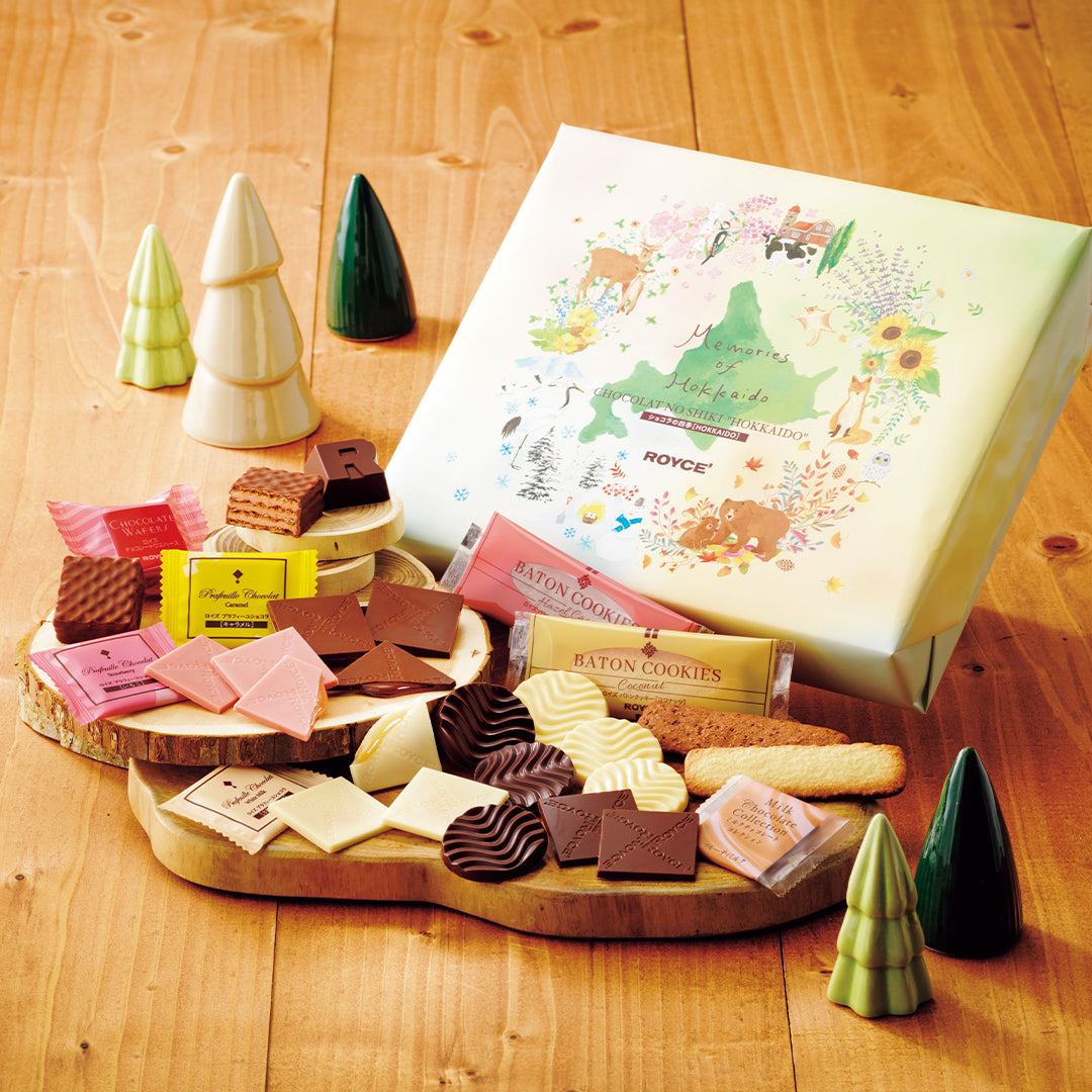 Chocolat No Shiki Hokkaido gift set featuring assorted chocolates, confections, and a decorative box, elegantly arranged on wooden stumps with model trees.