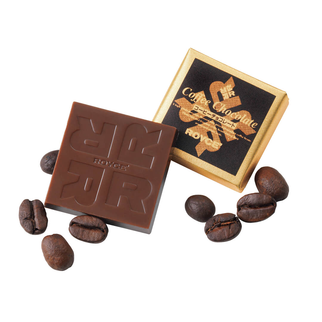 ROYCE' Chocolate - Coffee Chocolate - Image shows brown chocolate squares embossed with the letter R and word ROYCE' and an individually-wrapped chocolate square in gold and black with text saying Coffee Chocolate ROYCE'. Also included in the picture are loose coffee beans. 