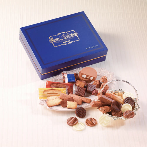 ROYCE’ Collection Blue features a royal-blue gift box with an assortment of chocolates, cookies, and truffles, elegantly displayed on a platter and in a silver basket.