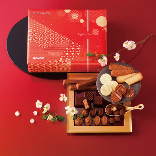 ROYCE' Collection Can Red: A red-and-gold box showcasing assorted chocolates and biscuits, including pralines, truffles, and chocolate wafers, elegantly presented with decorative branches.