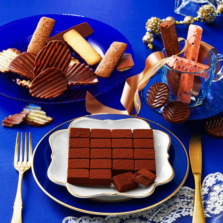 Image shows chocolates on plates with golden utensils.