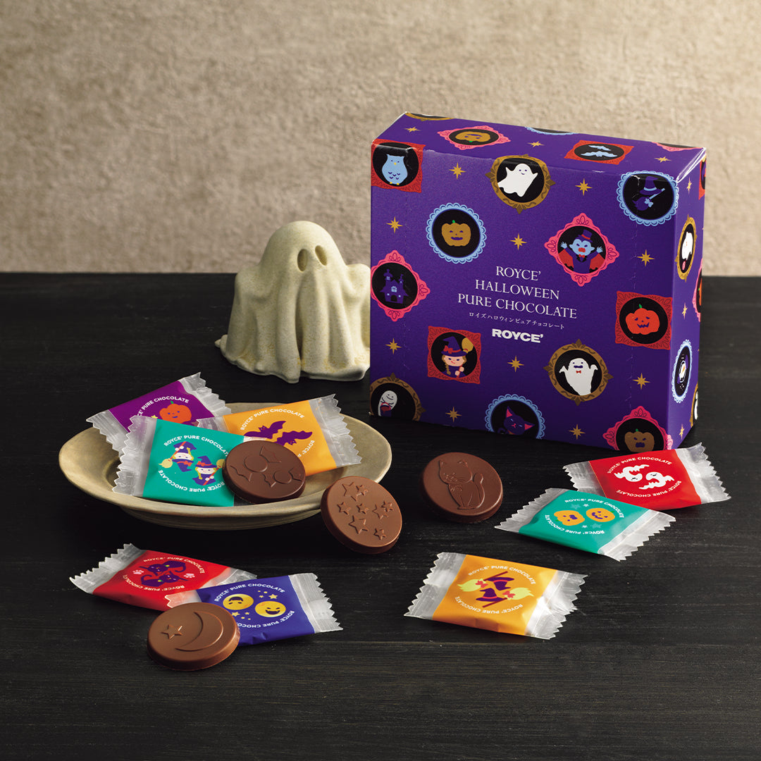 ROYCE' Halloween Pure Chocolate - Image shows a printed box with text saying ROYCE' Halloween Pure Chocolate ROYCE'. Image also shows a plate with chocolates and a ghost statue as accent.