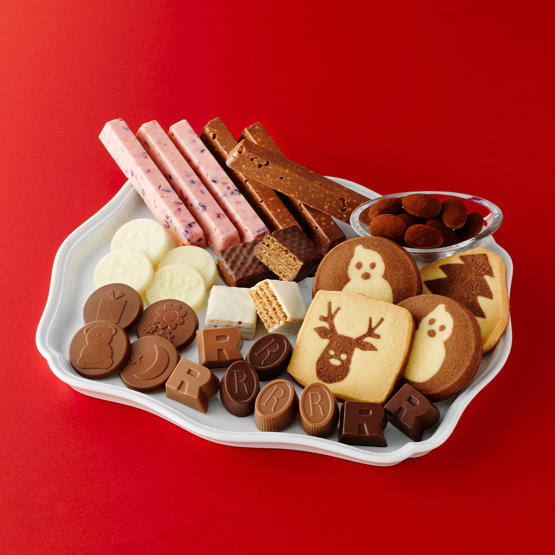 Image shows a white plate with chocolates on it. Background is in red.