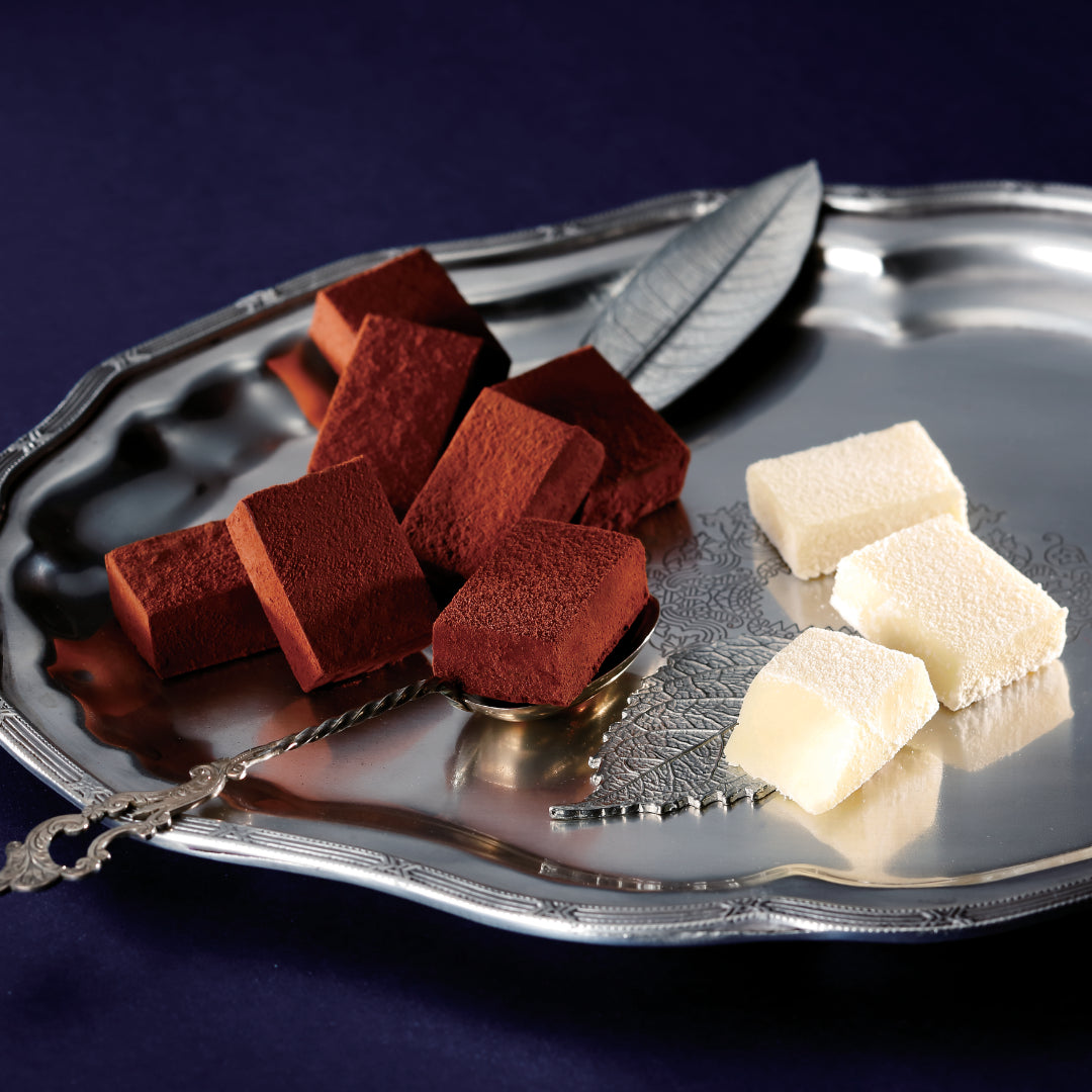 ROYCE' Signature Nama Chocolate Collection features different kinds of Nama Chocolates. Image shows chocolate blocks on a silver plate.