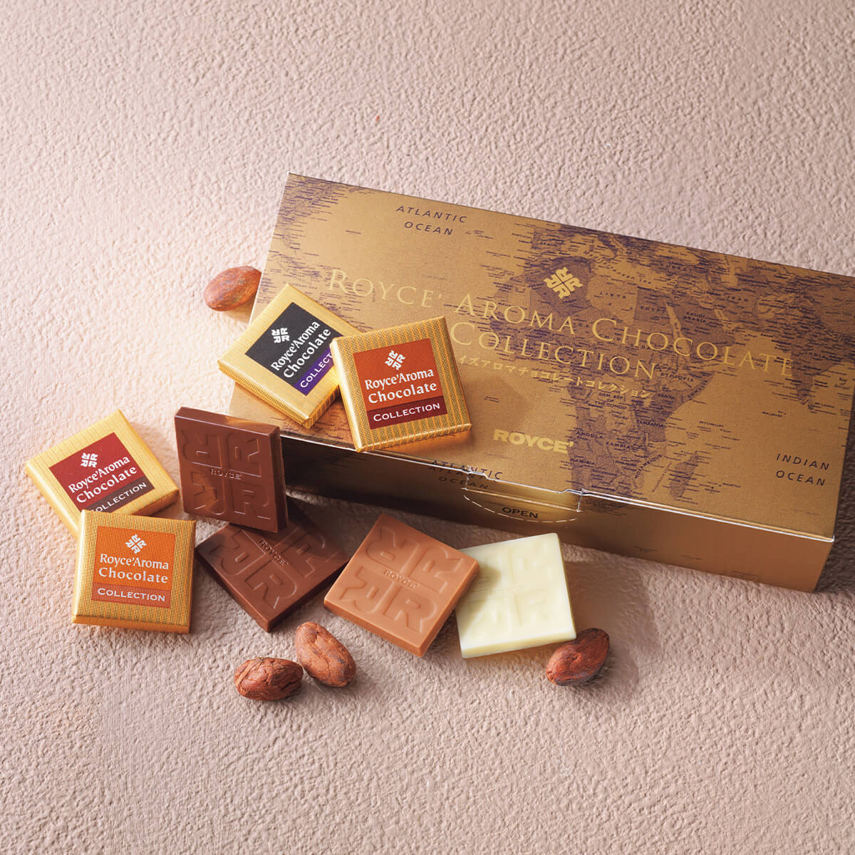 ROYCE' Chocolate - Image shows a brown printed chocolate box labeled ROYCE' Aroma Chocolate Collection with accents of chocolate squares and loose cacao beans.