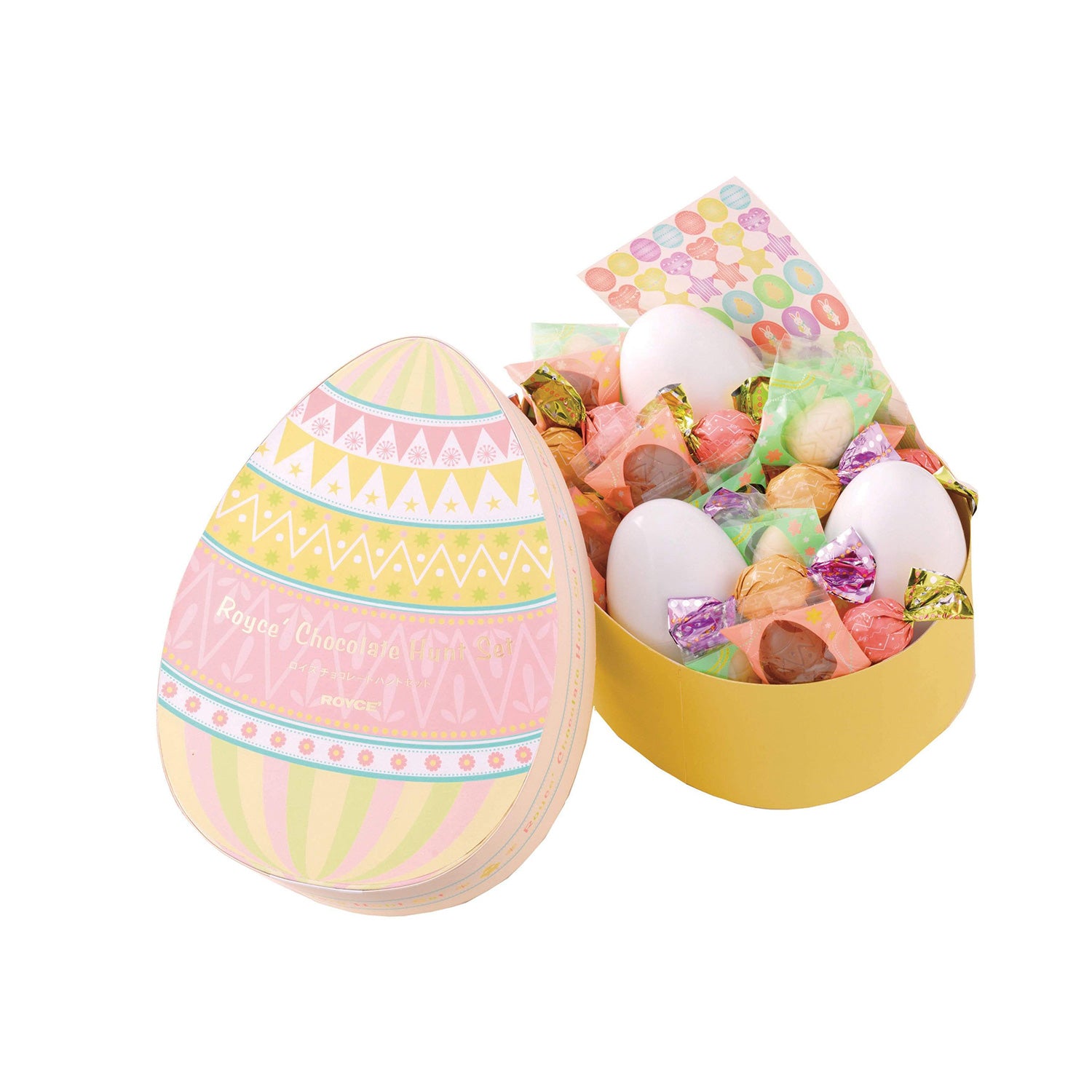 ROYCE' Chocolate - ROYCE' Chocolate Hunt Set - Image shows two egg-shaped boxes with a white background. Printed box on left has text saying ROYCE' Chocolate ROYCE'. Yellow box on right has plastic eggs, a sticker sheet, and a variety of confections in different colors and sizes.
