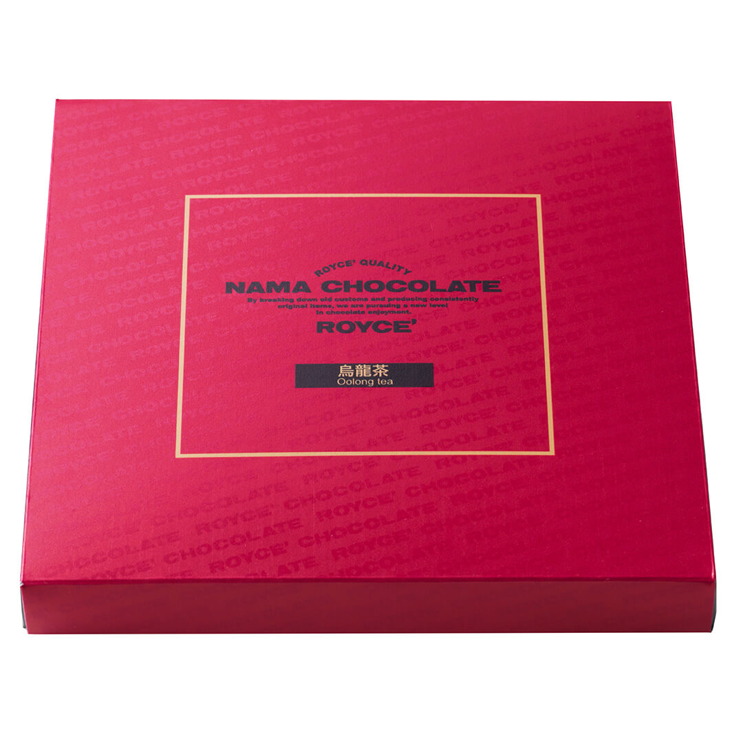 ROYCE' Chocolate - Nama Chocolate "Oolong Tea" - Image shows a red box. Gold square in the middle has text in the middle saying ROYCE' Quality Nama Chocolate By Breaking Down Old Customs And Producing Consistently Original Items, We Are Pursuing A New Level In Chocolate Enjoyment. ROYCE'. Oolong Tea.