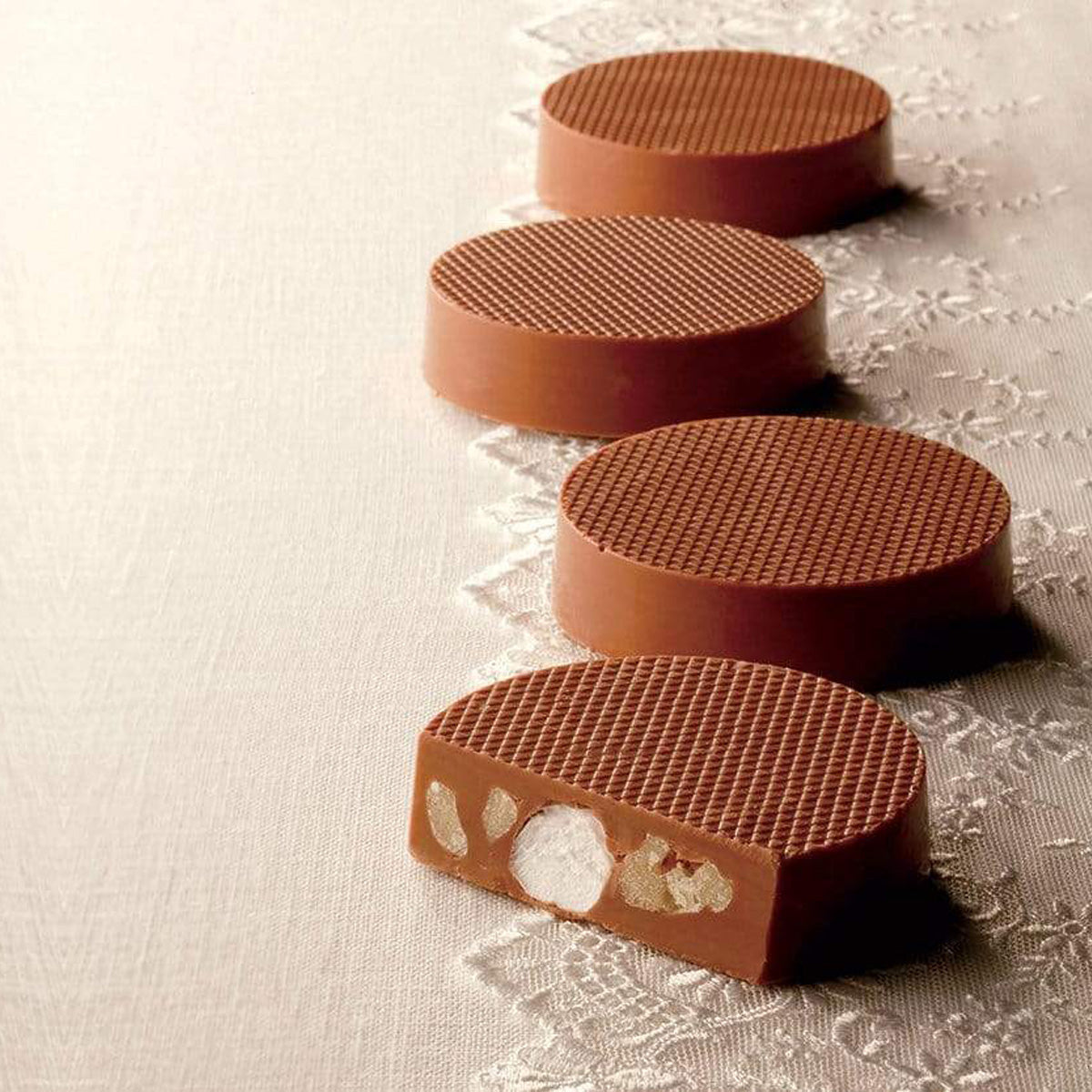ROYCE' Chocolate - Petit Kurumaro Chocolat (5 Pcs) - Image shows brown chocolate discs filled with marshmallows and walnuts on a light brown surface with lace.