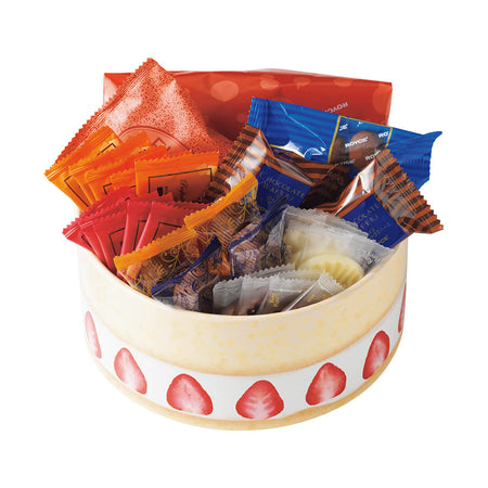 Image shows a yellow round box with white trim and illustrations of red strawberries. Inside the box are a variety of individually-wrapped confections in the colors orange, pink, red, green, brown, and white in different shapes and sizes. Background is in white.