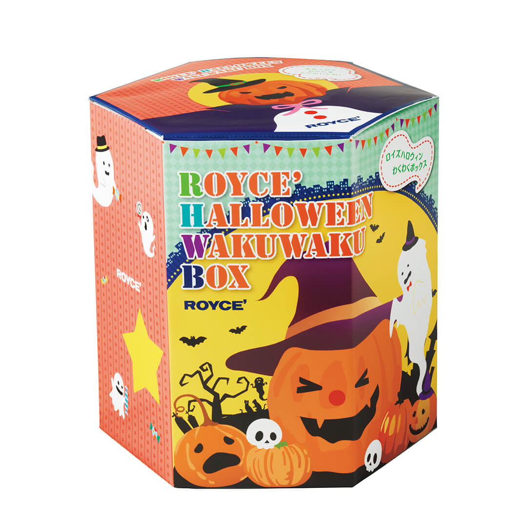 Image shows a hexagon-shaped printed box in the colors of red, blue, green, yellow, orange, and white. Text on the box (from top to front middle) says ROYCE'. ROYCE' Halloween Wakuwaku Box. ROYCE'. White text on the side of the box says ROYCE'. Seen in the picture are illustrations of ghosts, pumpkins with facial expressions, bats, trees, towers, skulls, tombstones, and cats. Background is in white.