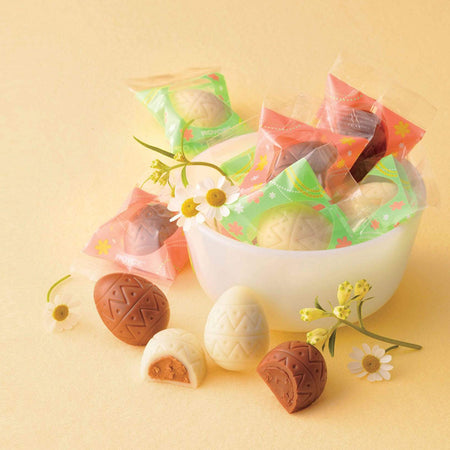 ROYCE' Chocolate - ROYCE' Chocolate Box "Sweet Eggs" - Image shows a white bowl filled with brown and white chocolate eggs with green and red wrapping. Accents include brown and white chocolate eggs and little flowers. Background is in yellow.
