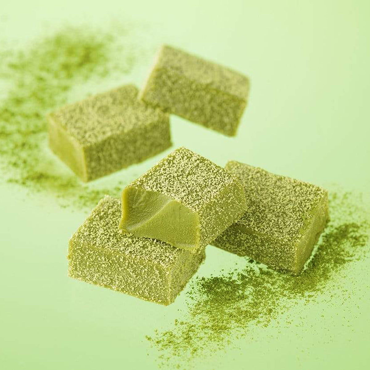 ROYCE' Chocolate - Nama Chocolate "Matcha" - Image shows green blocks of chocolates with green tea powder dusting. Background is green.