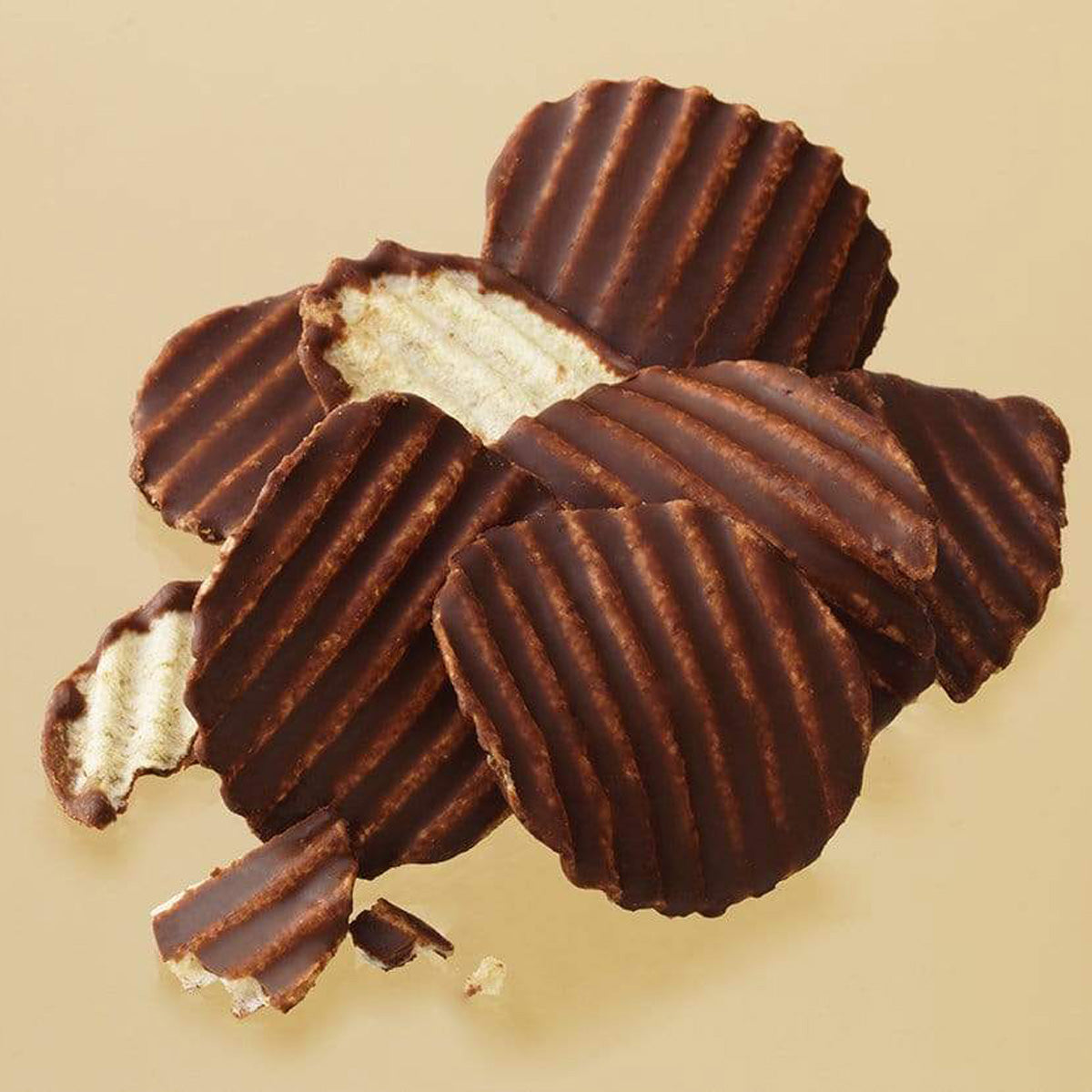 ROYCE' Chocolate - Potatochip Chocolate "Mild Bitter" - Image shows dark brown chocolate-covered potato chips with a ridged texture. Background is in light hue of brown.